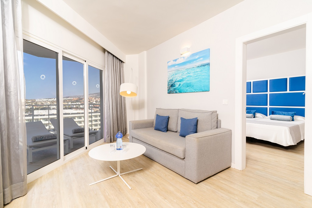 Soggiorno moderno con divano grigio e vista su Costa Adeje, Tenerife.