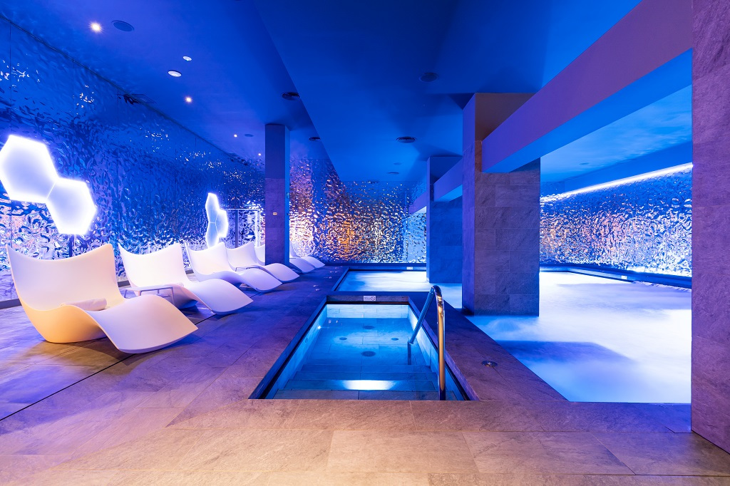 Piscina interna moderna con sedie bianche e luci blu, Tenerife.