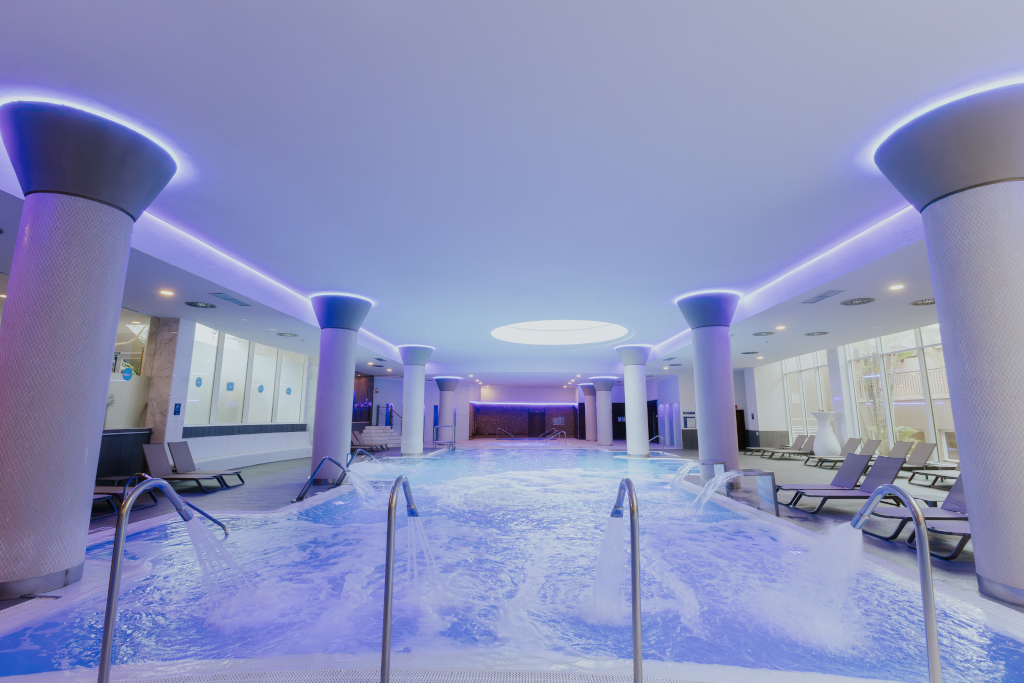 Piscina interna con area relax, luci soffuse e sedie a sdraio a Tenerife.