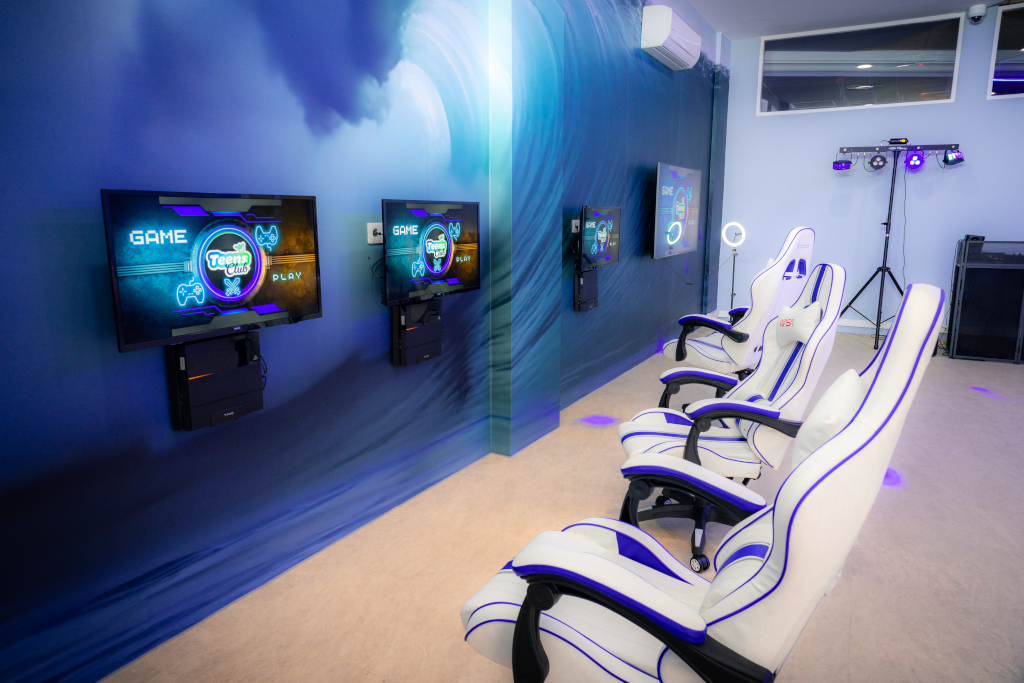Sala giochi con schermi e sedie bianche a Santa Cruz de Tenerife.