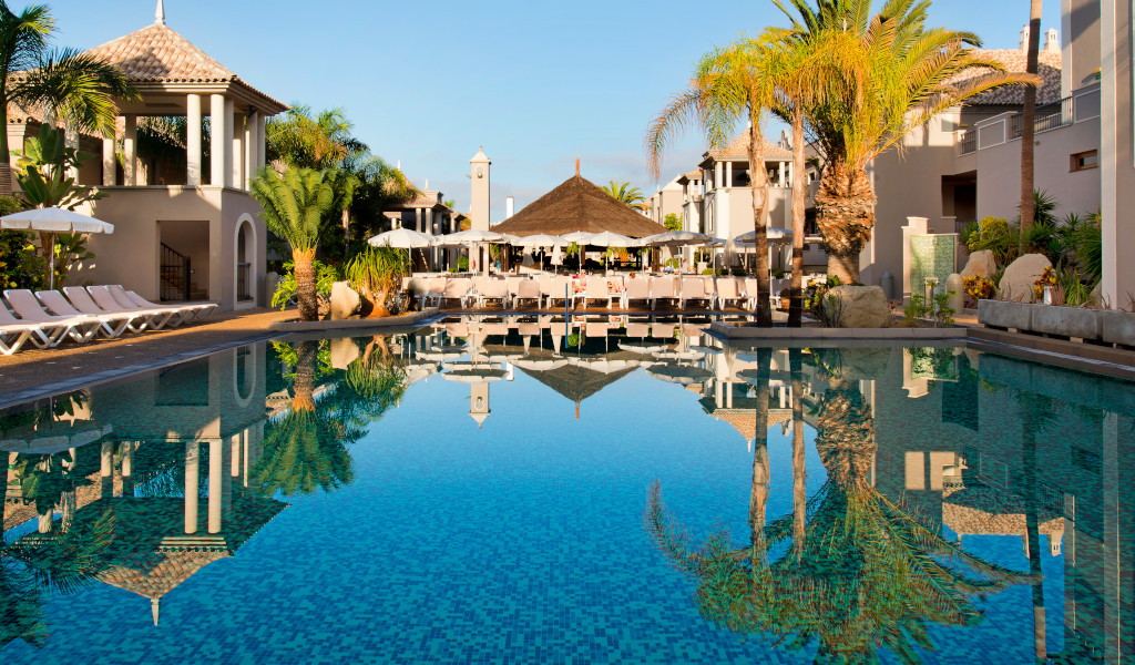Piscina e palme in un resort a Costa Adeje, Tenerife.