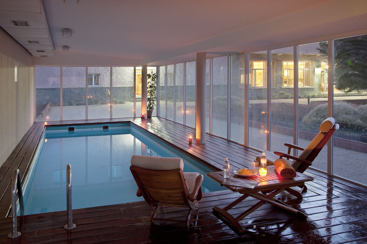 Piscina coperta con mobili in legno e candele a Tenerife.
