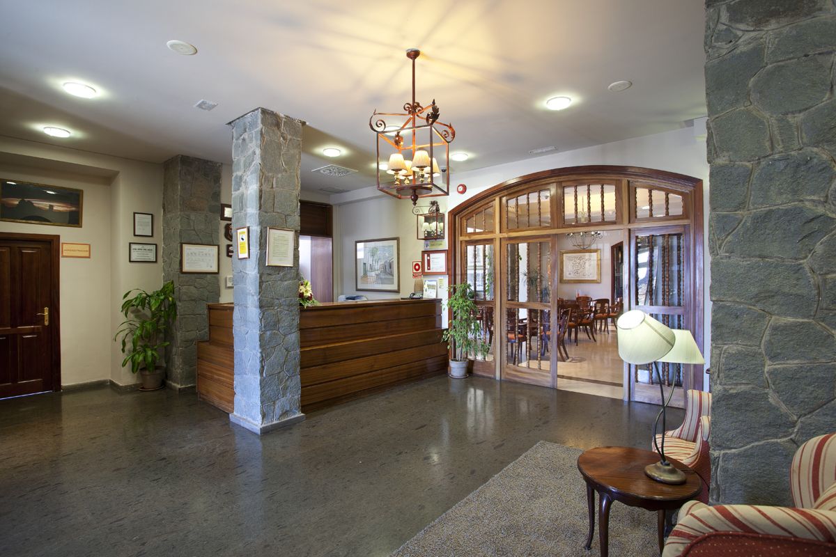 Reception dell'hotel a Tenerife con arredo in legno e lampada vintage.