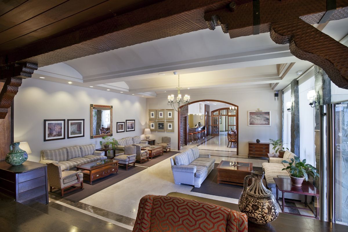 Salotto elegante di un hotel a Tenerife con divani e tavolini in legno.