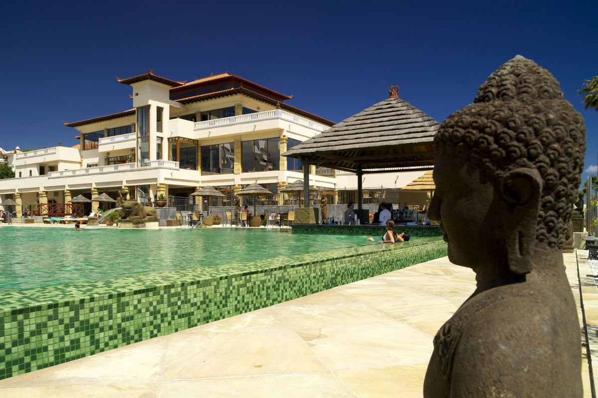 Piscina con statua di Buddha e edificio in stile orientale a Tenerife.