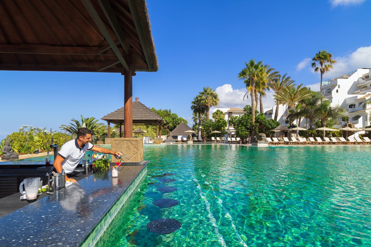 Barista prepara drink al bar della piscina in hotel a Tenerife.
