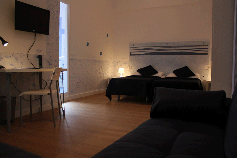 Camera da letto moderna con scrivania e TV a Santa Cruz de Tenerife.