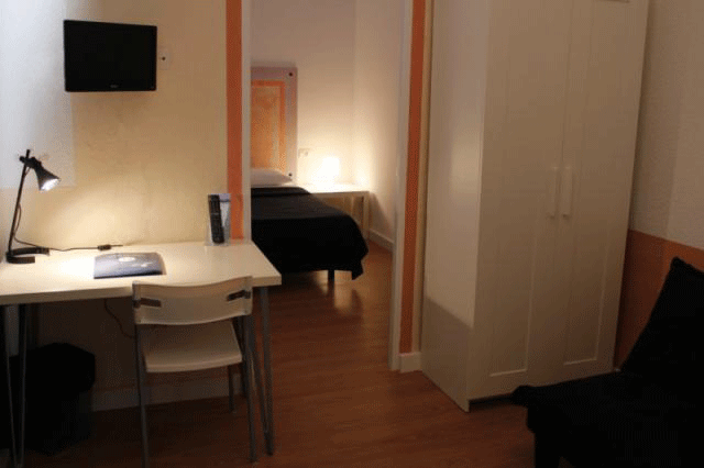 Camera da letto con letto singolo, scrivania e armadio in un alloggio a Tenerife.