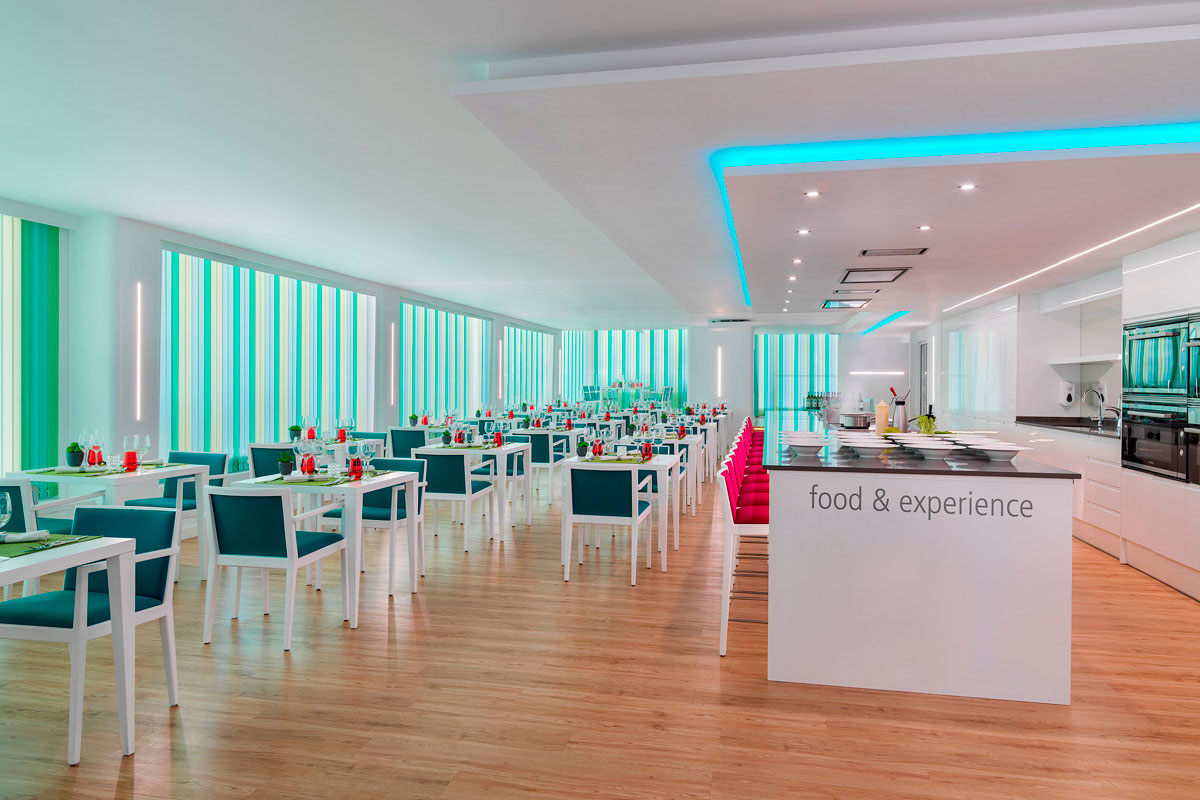 Sala da pranzo moderna con tavoli apparecchiati a Tenerife, scritta food & experience.