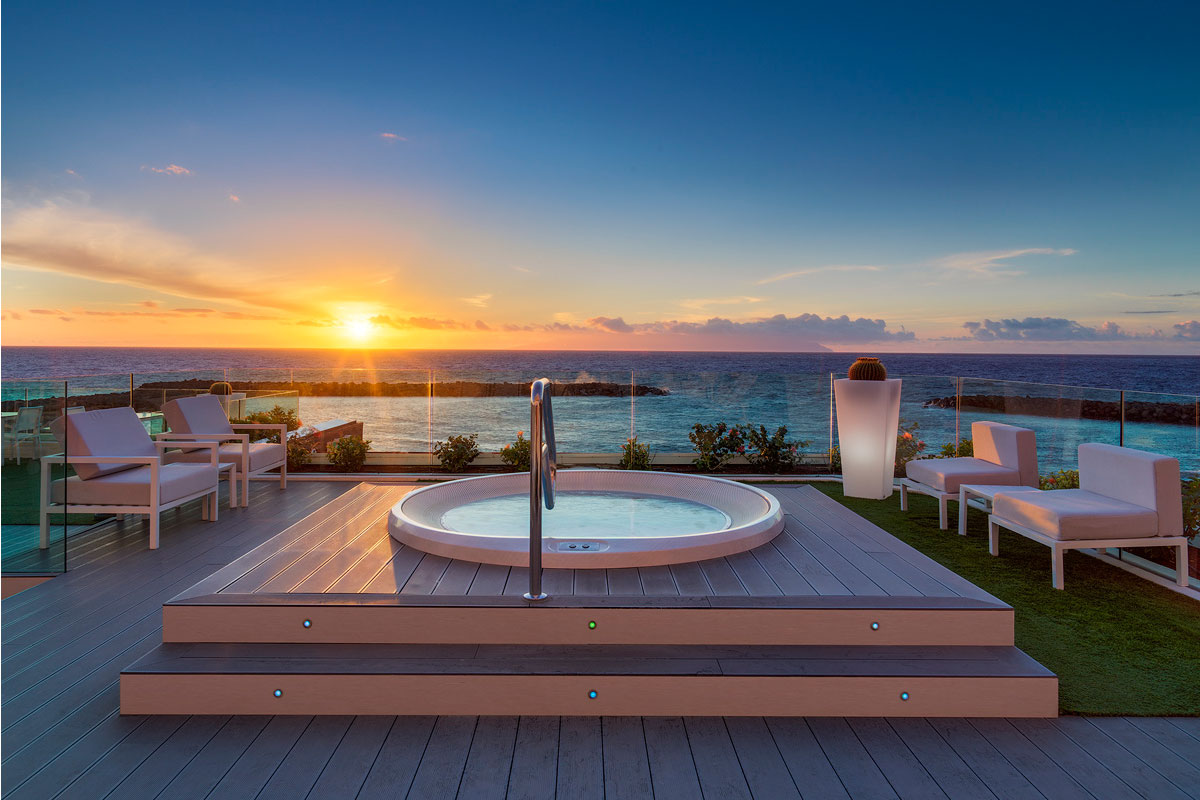 Vasca idromassaggio su terrazza con vista sull'oceano al tramonto a Tenerife.