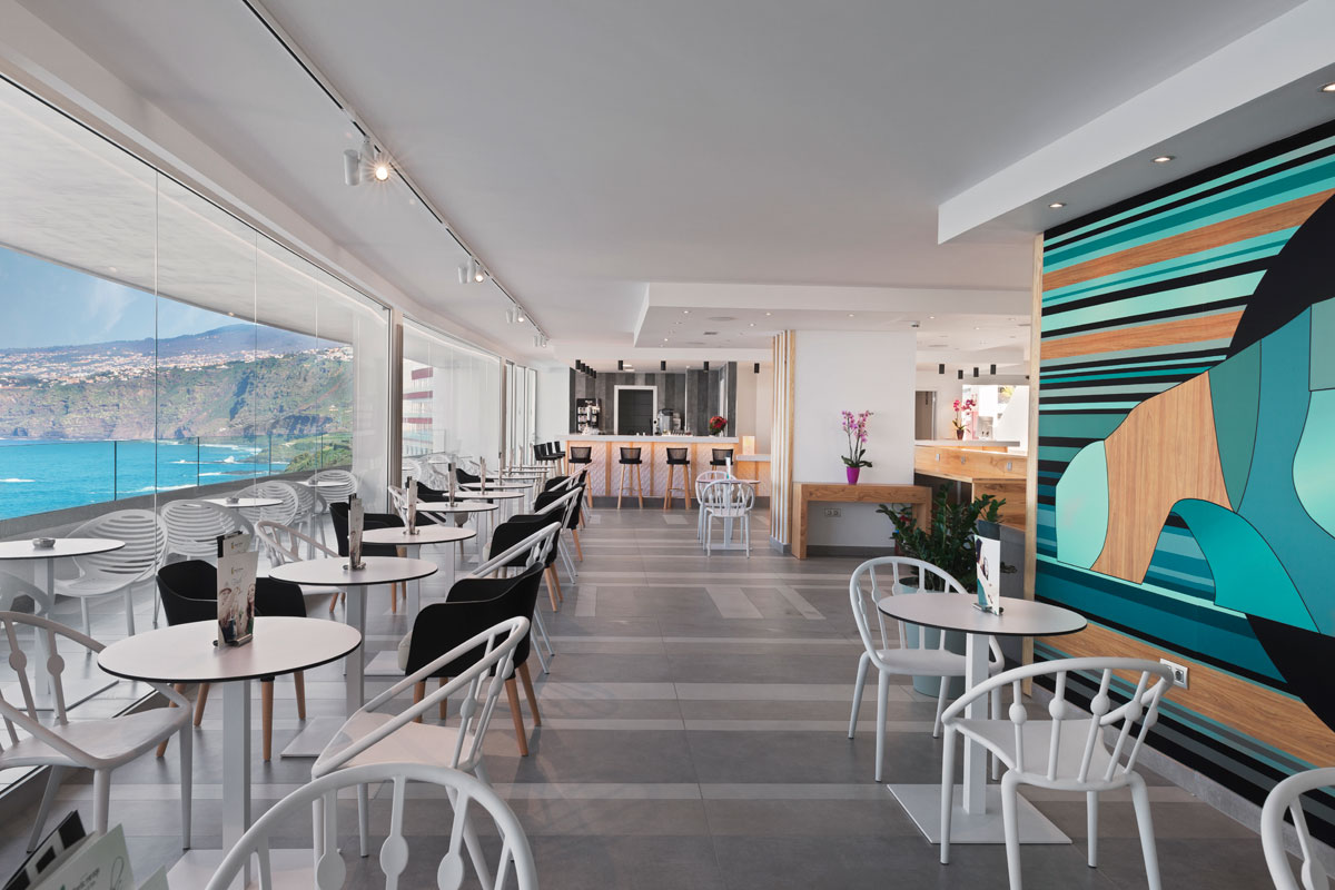 Sala da pranzo moderna con vista sull'oceano a Tenerife e parete colorata.