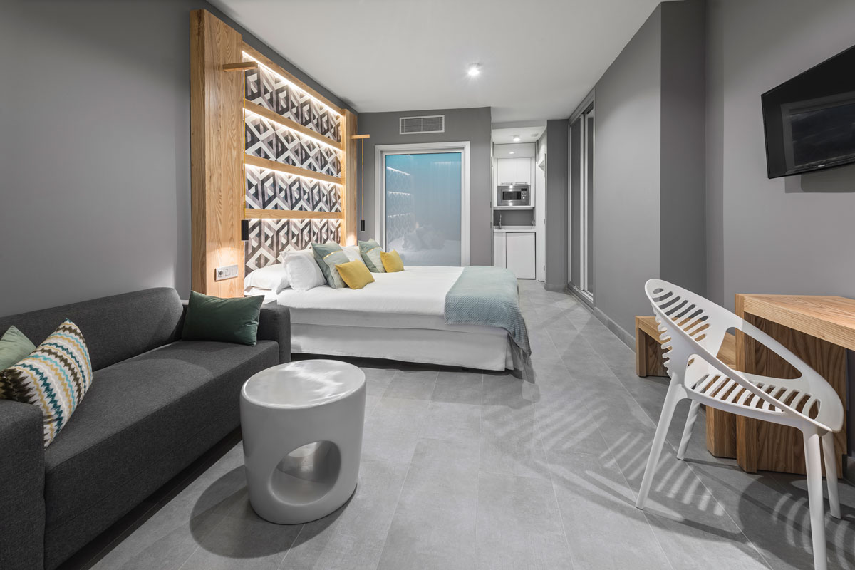 Camera moderna e spaziosa con letto, divano e cucina a Tenerife.