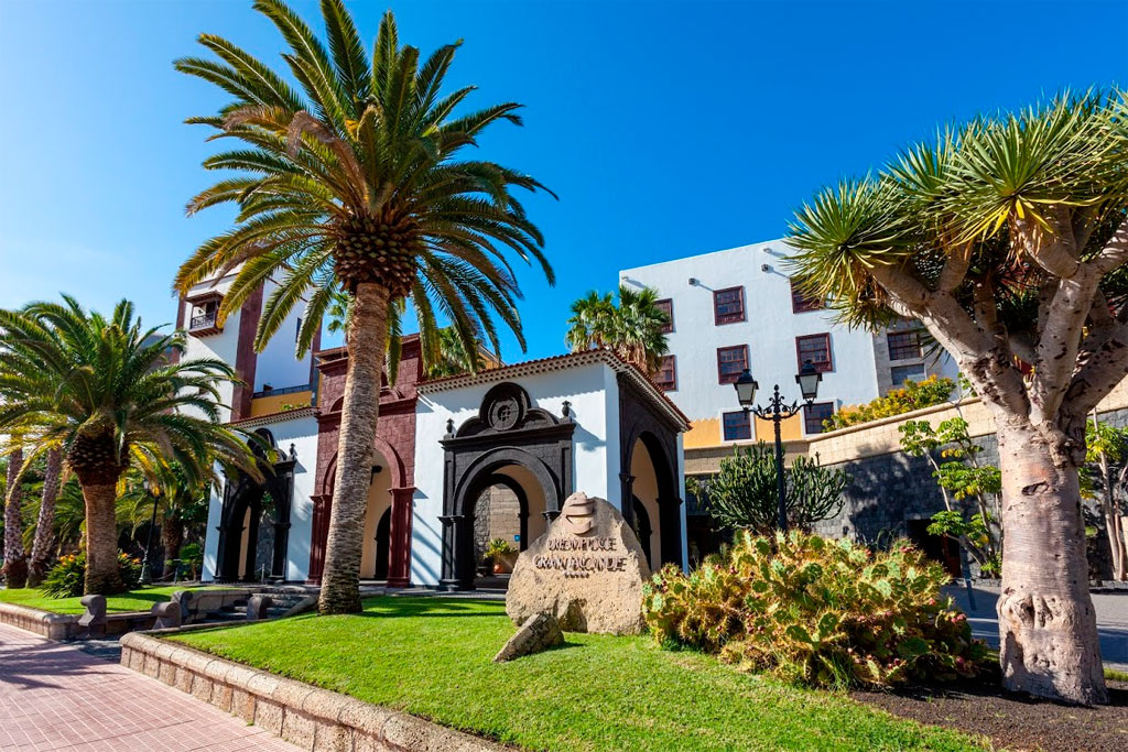 Edificio storico a Garachico, Tenerife, con palme e giardino verde.