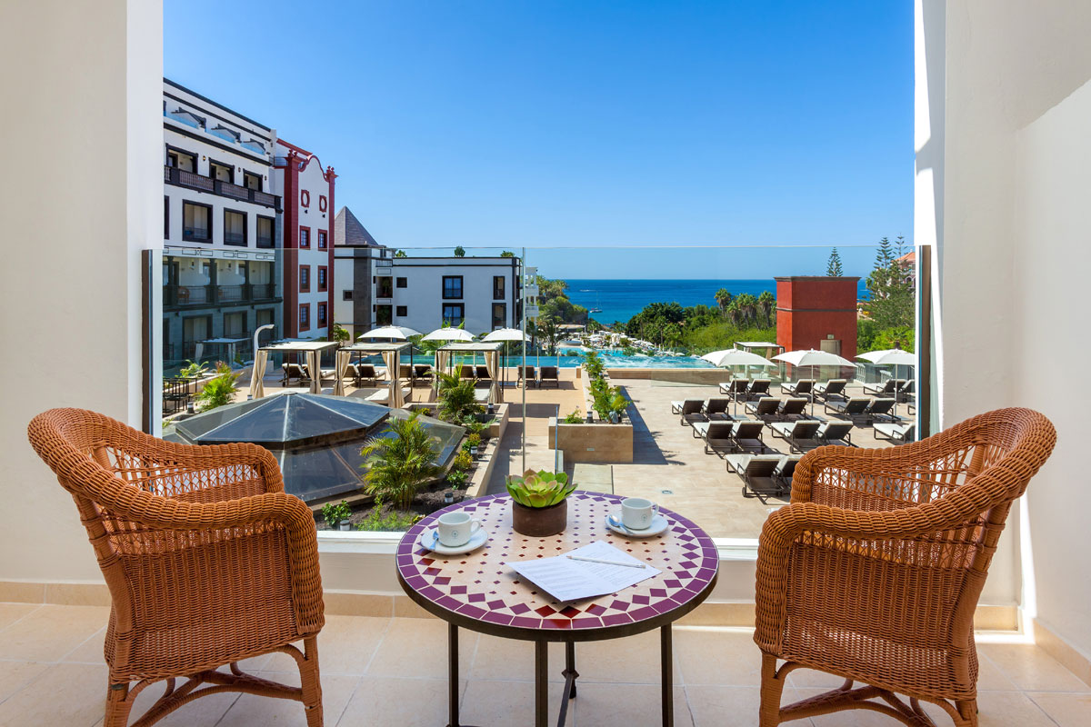 Terrazza con vista mare ad Adeje, Tenerife, con tavolo e sedie in primo piano.