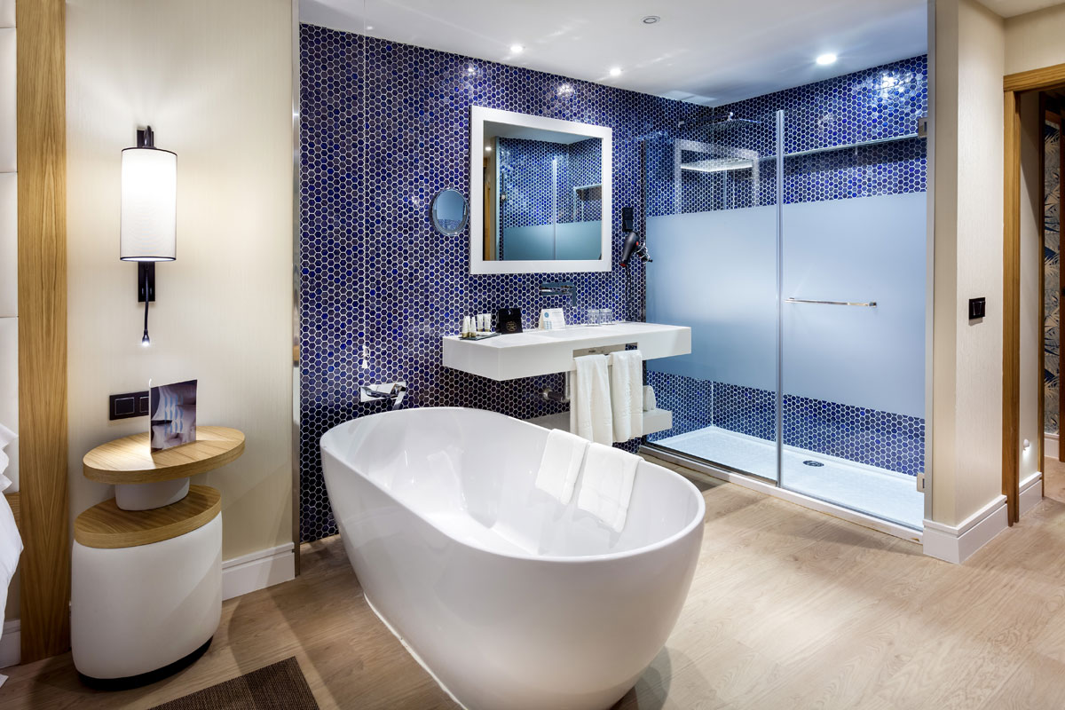 Bagno moderno con vasca bianca, doccia e piastrelle blu a Tenerife.