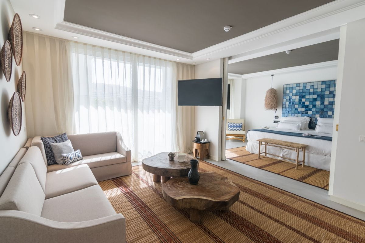 Soggiorno con divani beige e camera da letto con pannello blu a Tenerife.
