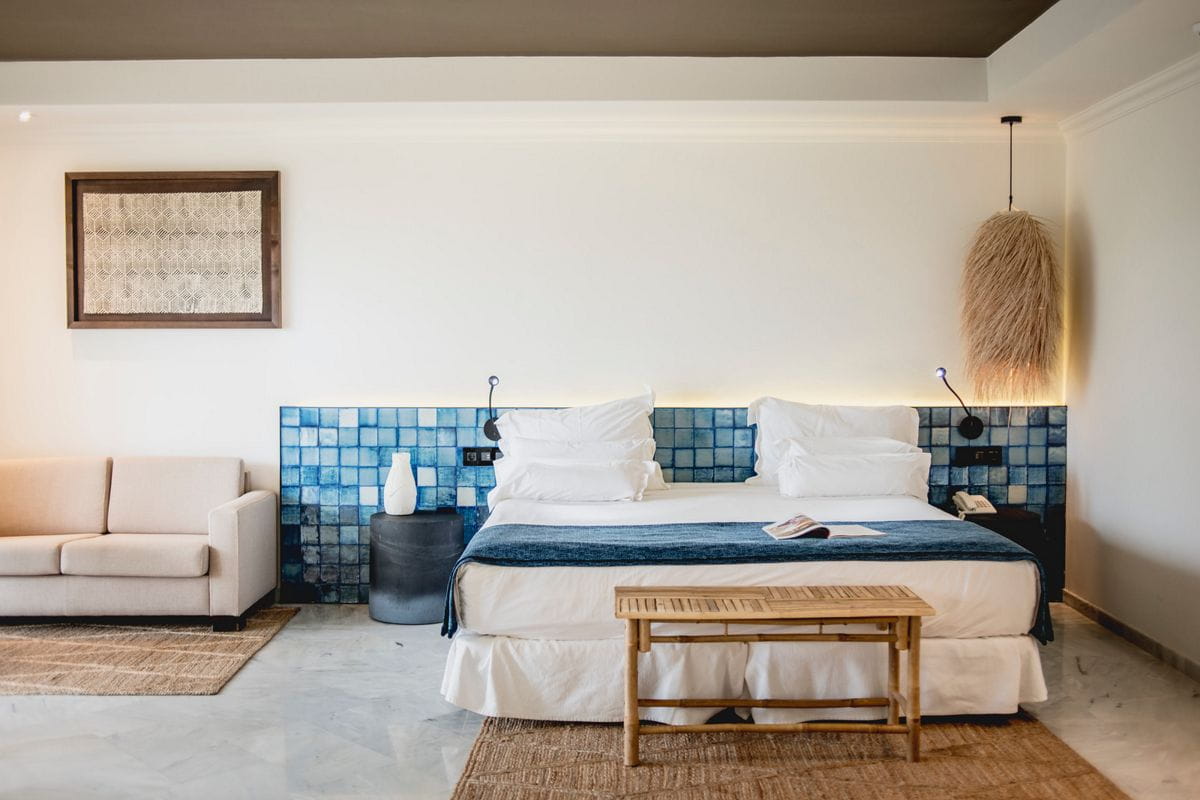 Camera d'albergo a Tenerife con letto matrimoniale, divano e decorazione murale.