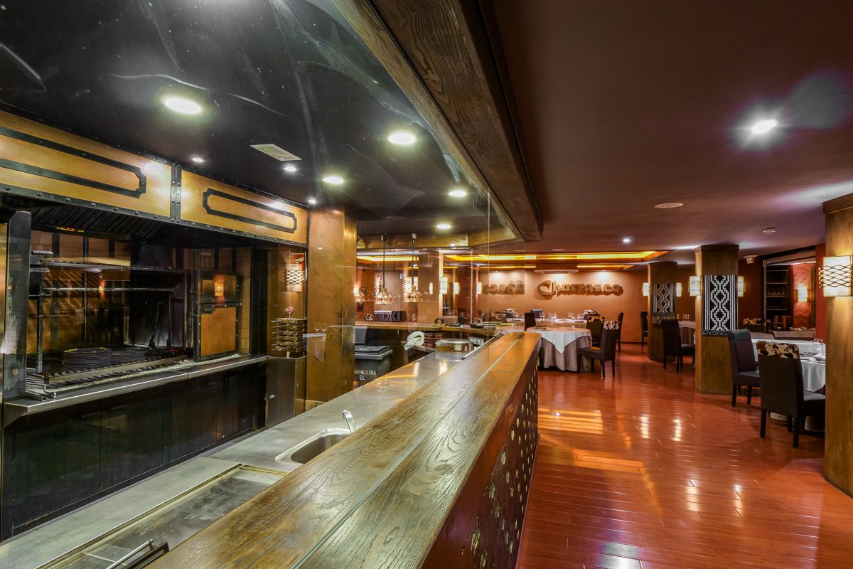 Ristorante interno con tavoli apparecchiati a Tenerife. Scritta: Churrasco.