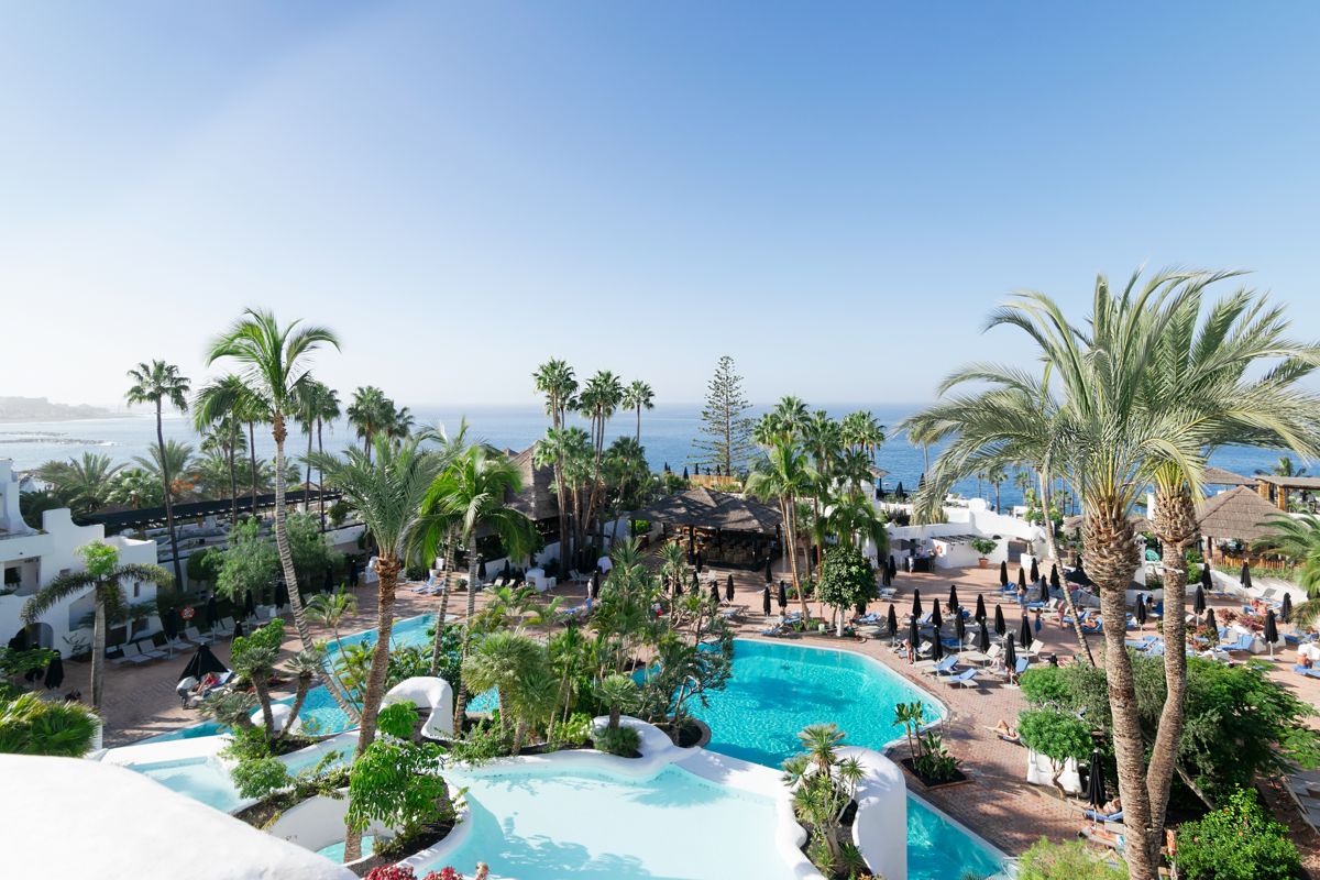 Piscina e giardini tropicali del resort a Tenerife, con vista mare.