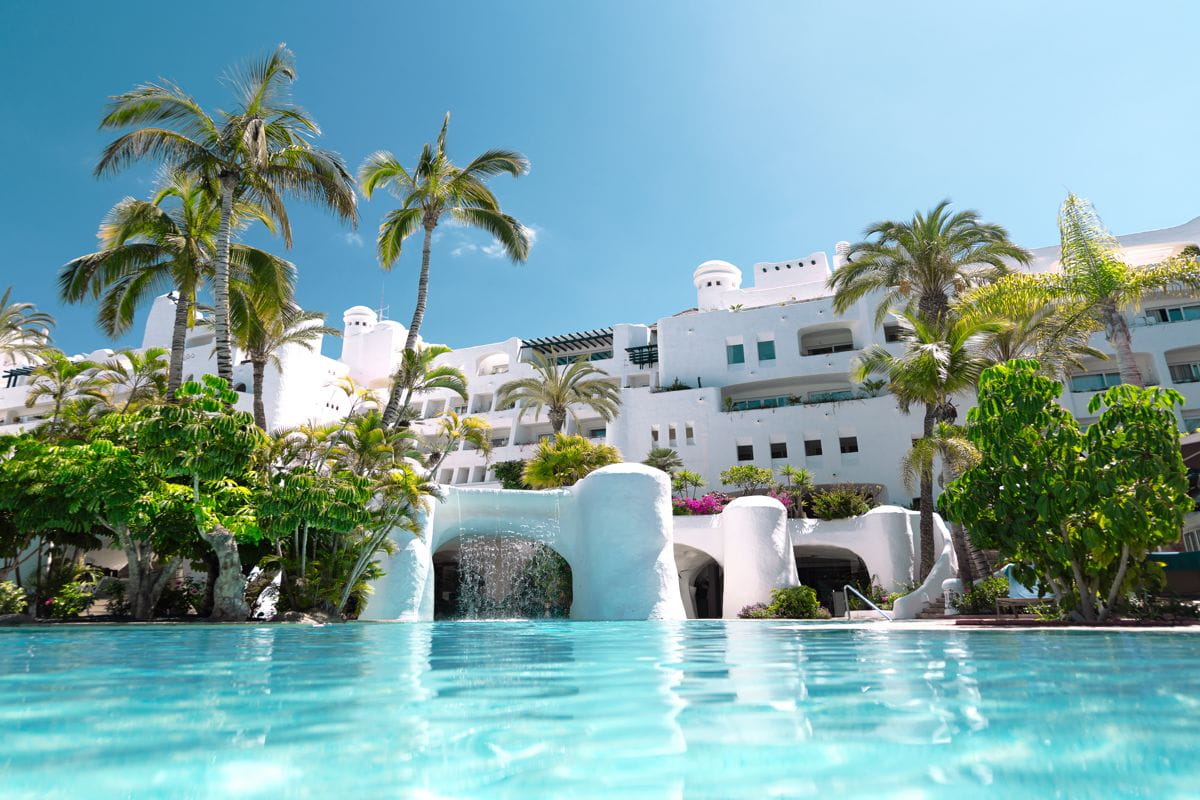 Edificio bianco con palme e piscina a Tenerife.