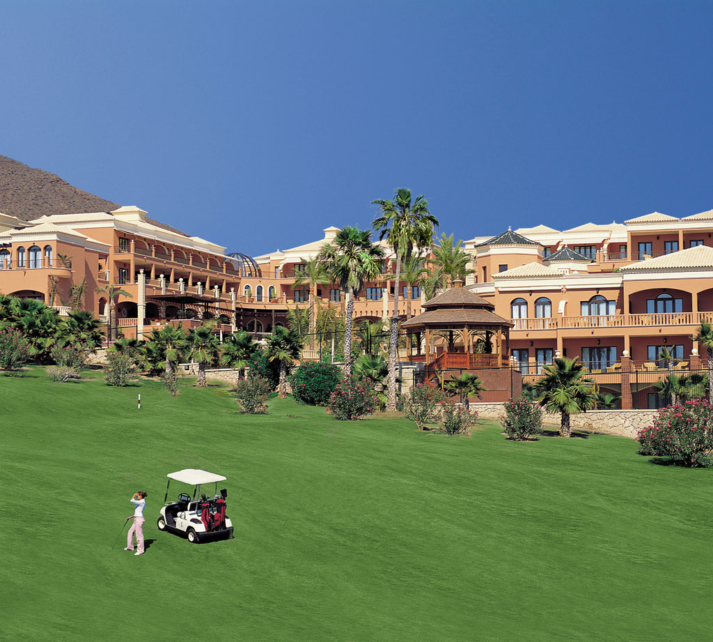 Giocatore di golf con carrello davanti a un hotel a Tenerife.