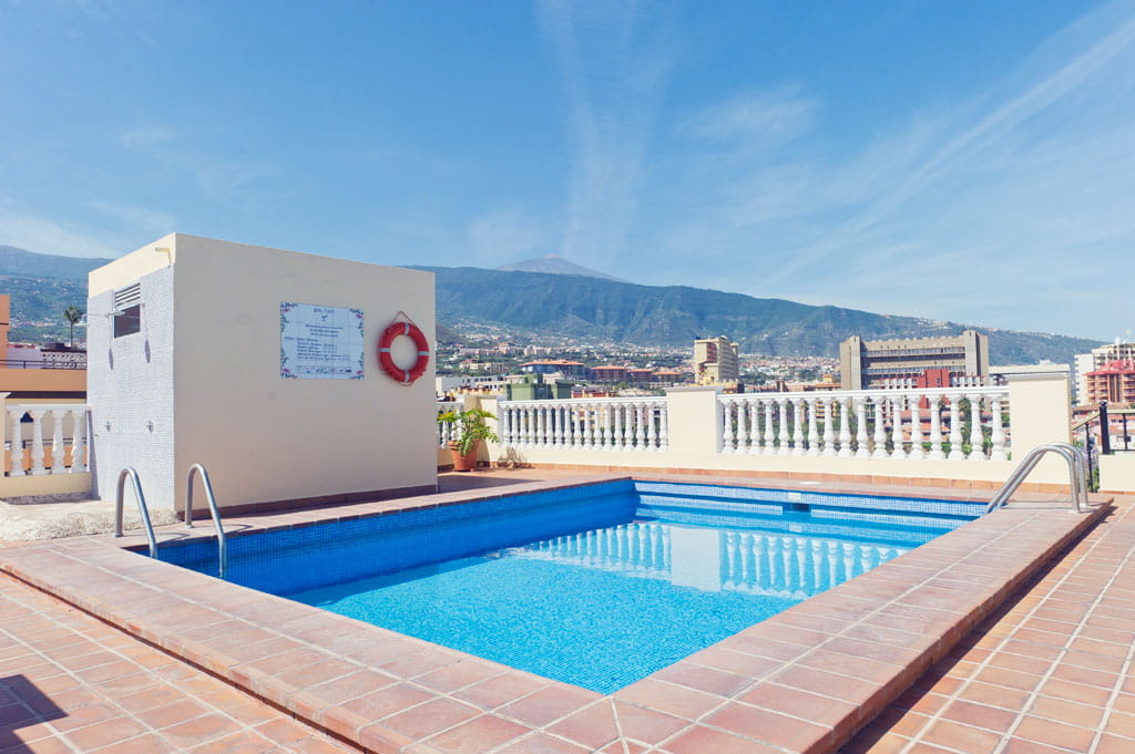 Piscina sul tetto a Santa Cruz de Tenerife con vista della città e montagna.