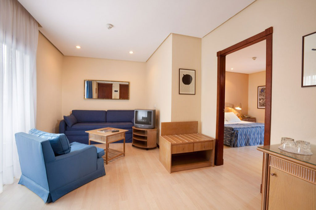 Soggiorno con divano blu e porta verso camera da letto a Tenerife.