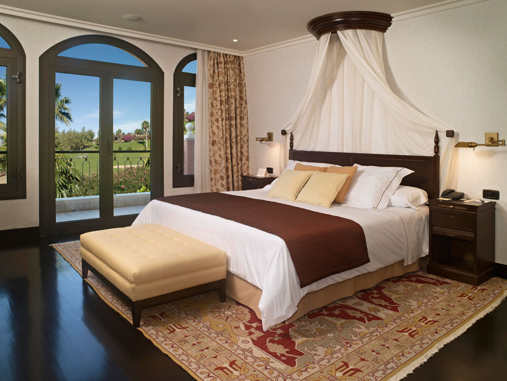 Camera da letto elegante con letto matrimoniale e vista sul giardino a Tenerife.