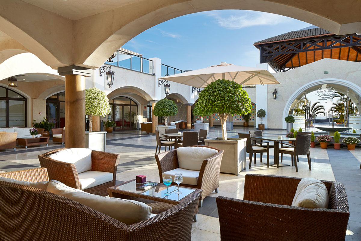 Cortile con sedie, ombrellone e piante a Costa Adeje, Tenerife.