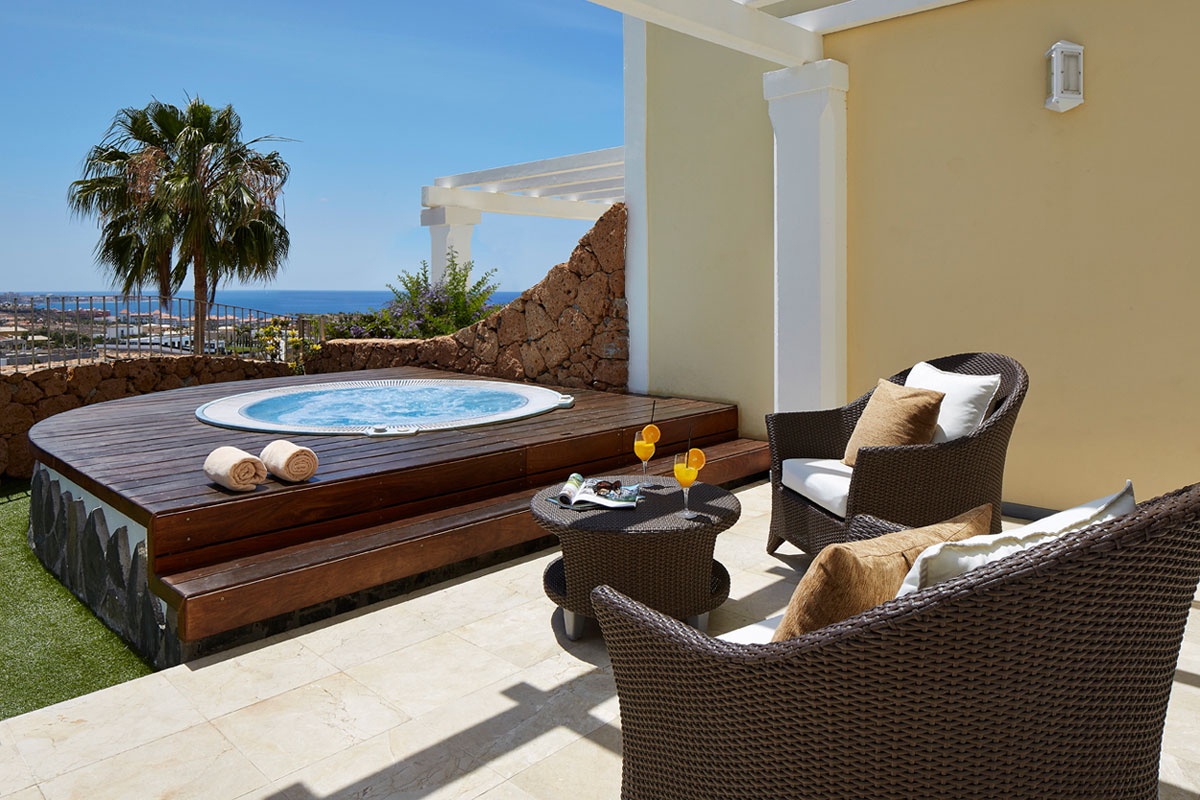 Terrazza con jacuzzi, sedie di vimini e vista mare a Tenerife.