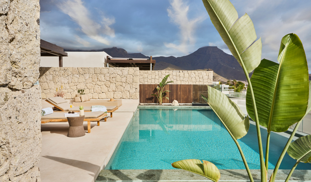 Piscina con lettini e montagne sullo sfondo a Tenerife.