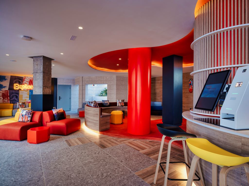 Hall moderno con divani rossi e tecnologia a Santa Cruz de Tenerife.
