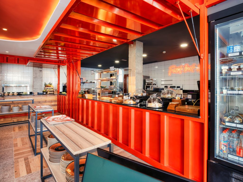 Interno di un ristorante a Tenerife con tavoli in legno e bancone rosso.