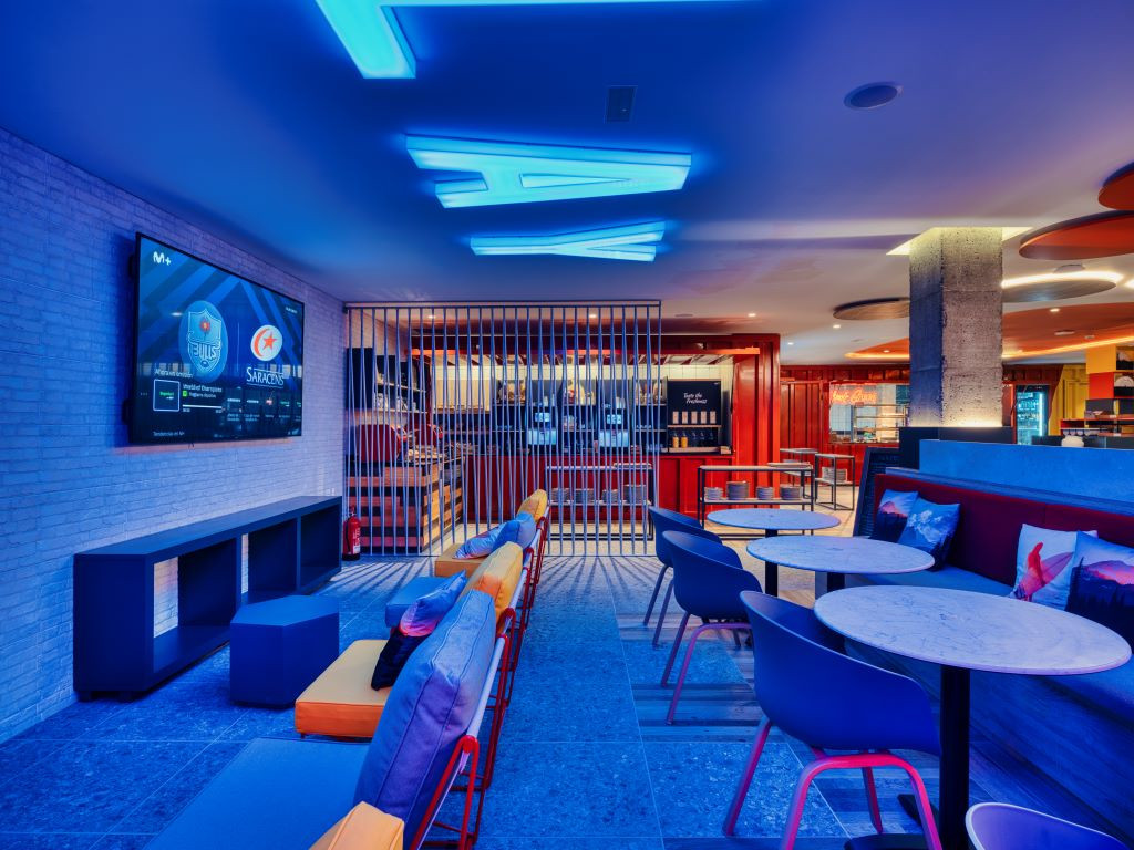 Area di sosta illuminata a Tenerife bar con schermo e tavoli.