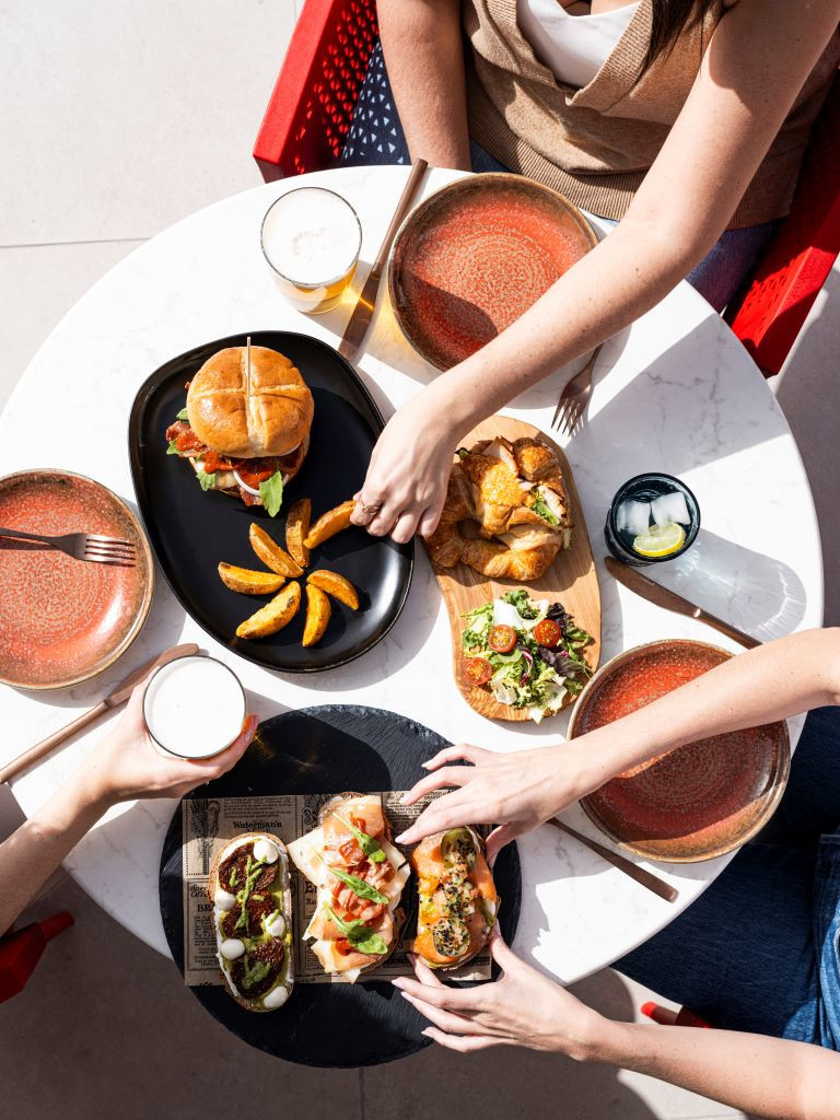 Tavolo con hamburger, patatine, insalata e bevande in un ristorante a Tenerife.