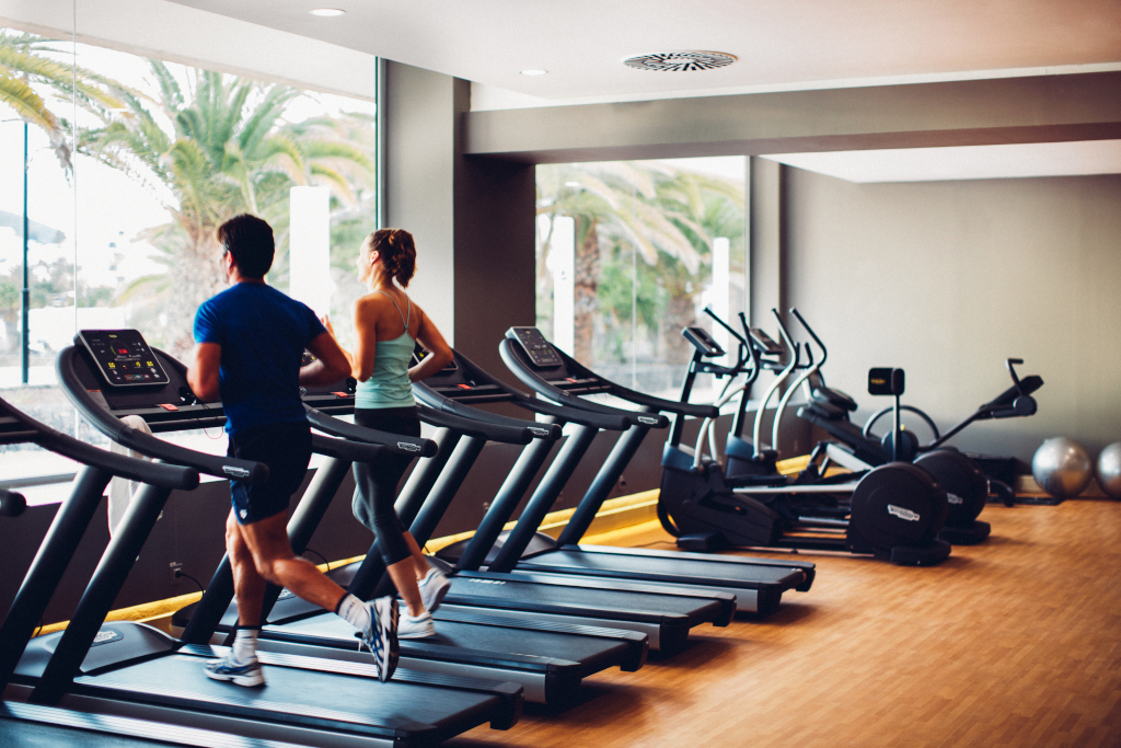 Due persone corrono su tapis roulant in una palestra a Tenerife.