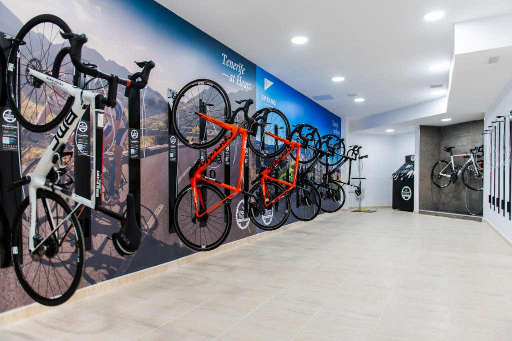 Biciclette appese al muro in uno showroom con scritta Tenerife at Heart.