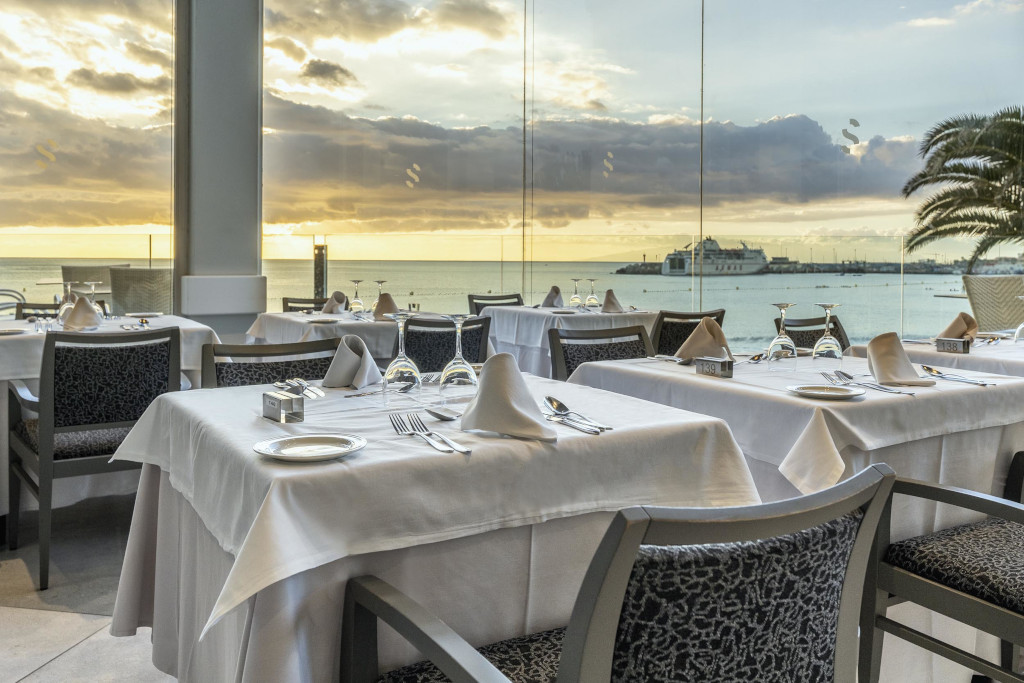 Tavoli apparecchiati in un ristorante con vista mare al tramonto a Tenerife.