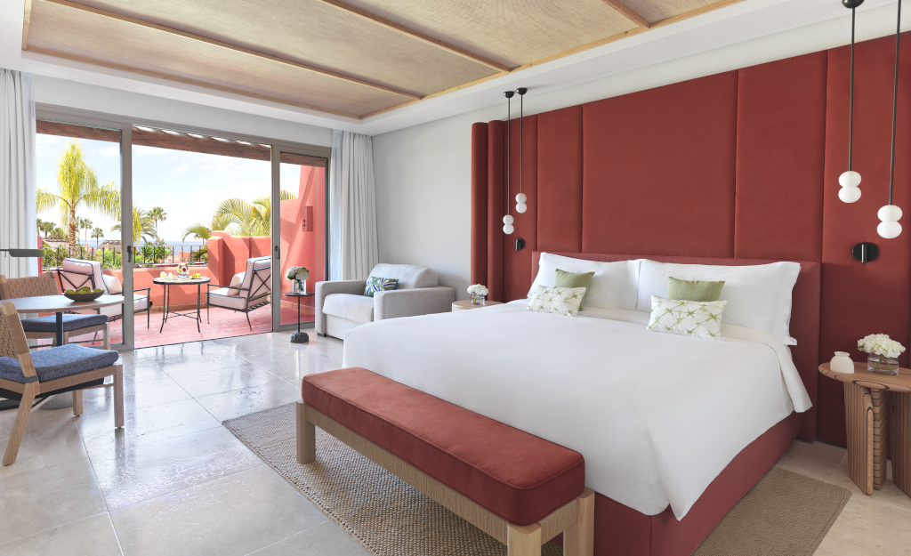 Camera da letto con letto matrimoniale, divano e terrazza vista giardino a Tenerife.