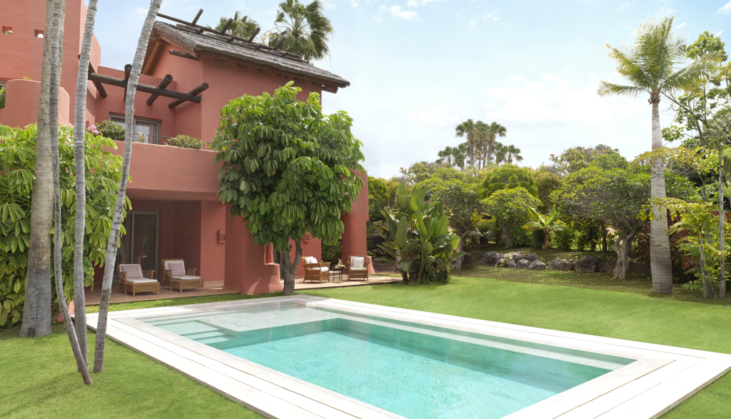 Casa rossa con piscina e giardino verde a Tenerife.