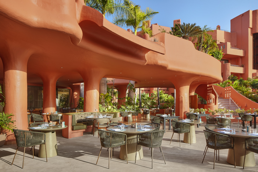 Terrazza di un ristorante a Tenerife con tavoli apparecchiati e palme.