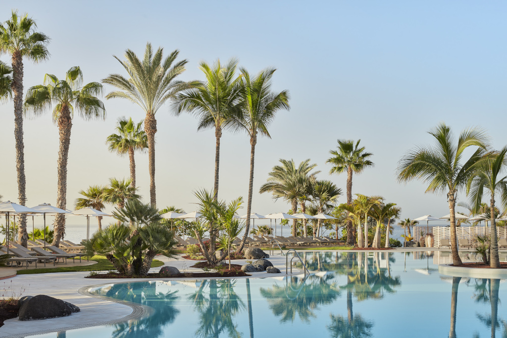 Piscina con palme e lettini a Costa Adeje, Tenerife.