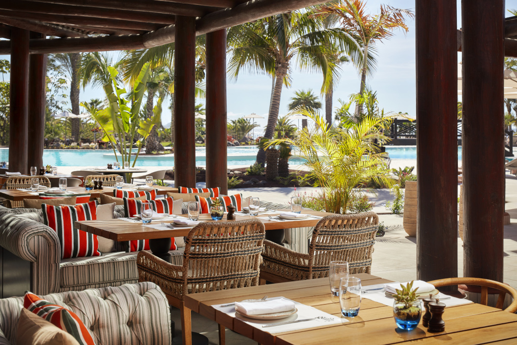 Ristorante all'aperto con palme e piscina a Costa Adeje, Tenerife.