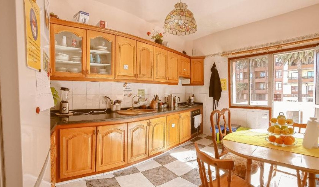 Cucina luminosa con mobili in legno e tavolo rotondo a Puerto de la Cruz.