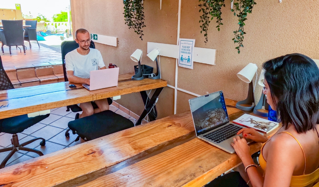 Persone lavorano su laptop in un ufficio esterno a Tenerife.