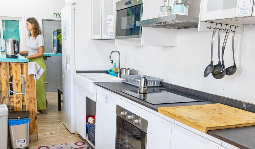 Cucina moderna con elettrodomestici e donna in piedi a Los Cristianos, Tenerife.