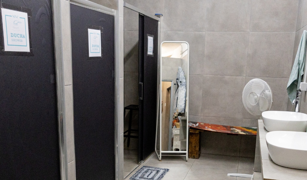 Docce e lavabi in bagno pubblico a Tenerife. Cartelli: DUCHA SHOWER.