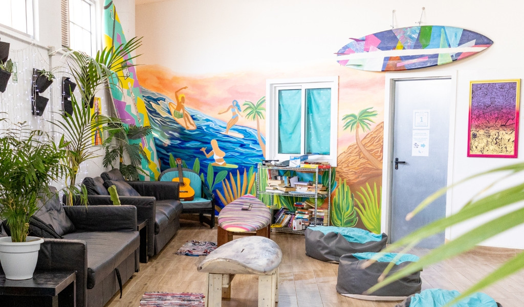 Sala con murale colorato, divani, chitarra e libri a Tenerife.