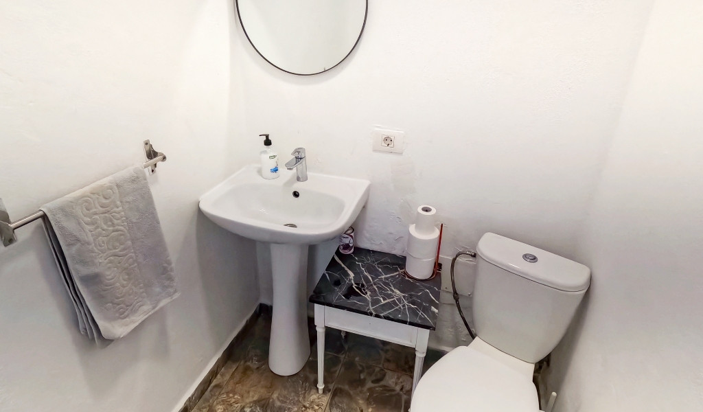 Bagno con lavandino, specchio, asciugamano e WC a Tenerife.