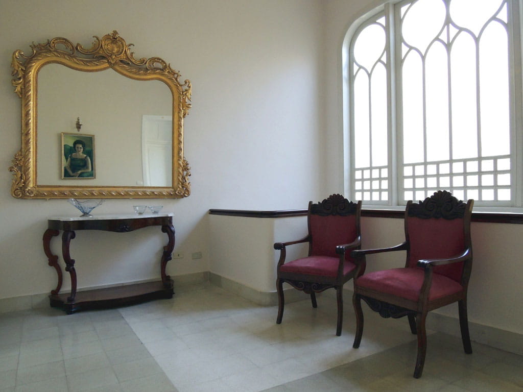 Sala con specchio dorato, dipinto, tavolo e due sedie vicino a finestra a Tenerife.
